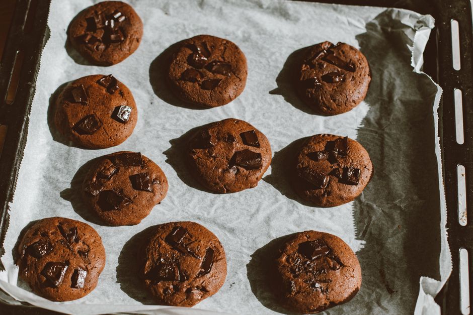 Cookies moelleux au chocolat sur une plaque de cuisson, prêts à être cuits, avec des morceaux de chocolat sur le dessus.