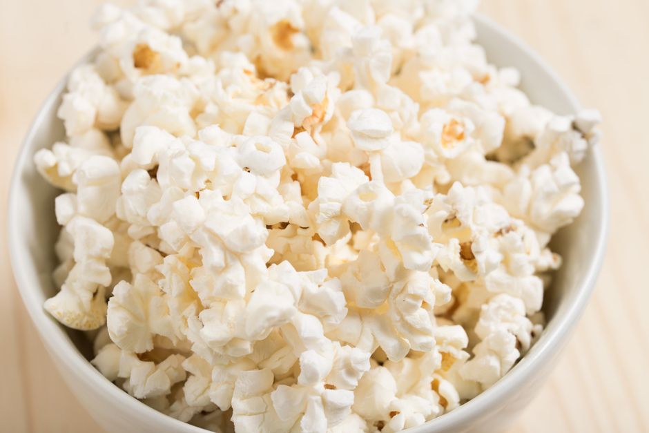 Bol de popcorn soufflé, léger et aéré, prêt à être assaisonné pour un mélange sucré-salé.