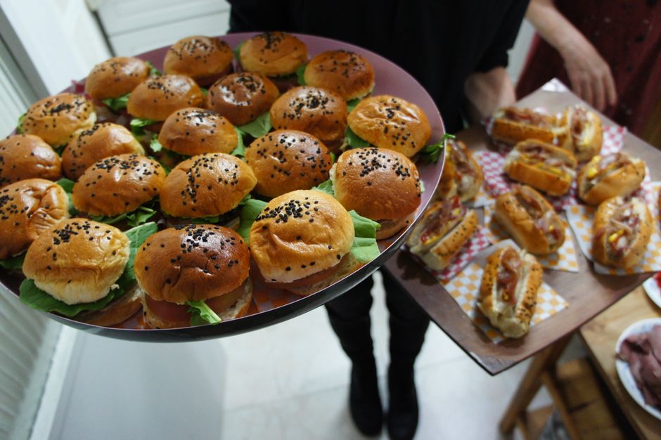 Plateau de mini-sandwichs sucrés en brioche garnis de confiture et de fruits, présentés avec des garnitures variées.