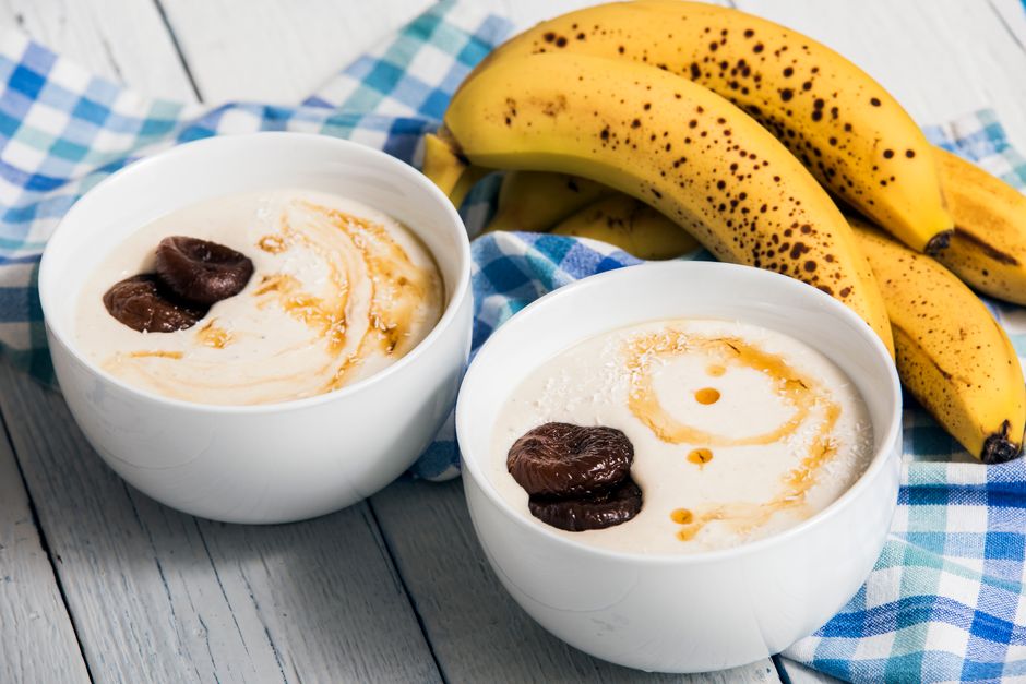 Deux bols de glace minute à la banane, garnis de morceaux de banane et de coulis, posés sur un torchon à carreaux.