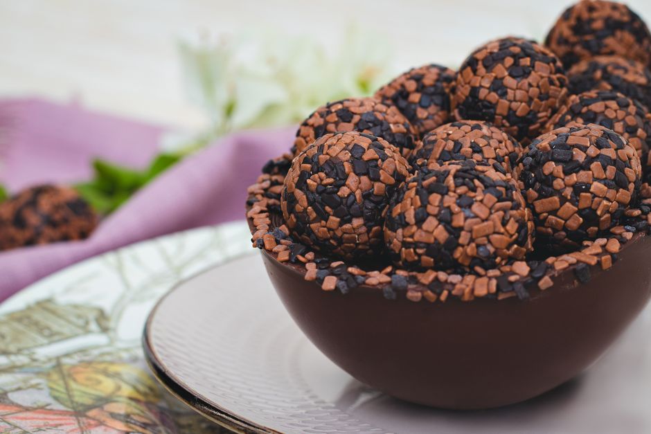 Boulettes énergétiques au cacao et dattes, garnies de pépites de chocolat, dans un bol en chocolat.