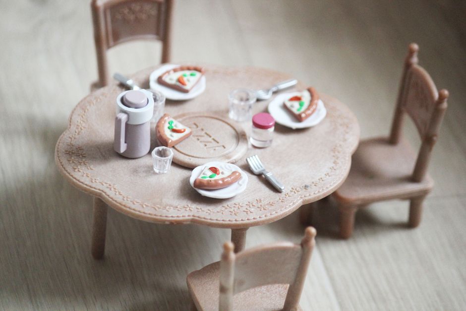 Mini-pizzas sucrées servies sur une table en jouet avec des chaises et des couverts.